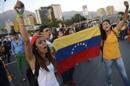 Students hold a Venezuelan national flag as they protest against the government of President Nicolas Maduro aklong a main highway in Caracas on February 13, 2014