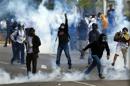 Anti-government protester throws stones to police during a protest at Altamira square in Caracas