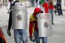 Anti-government protesters cover themselves with shields during riots in Caracas