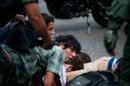 An anti-government demonstrator is held on the ground along with others, as he is detained by the Bolivarian National Guard, during clashes at a protest in Caracas, Venezuela, Wednesday, May 14, 2014. Members of Venezuela's opposition pulled out of crisis negotiations with the government as security forces arrested scores of people in fierce clashes with demonstrators. (AP Photo/Alejandro Cegarra)
