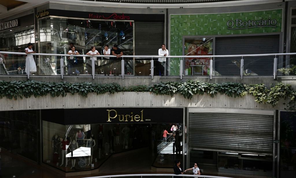 People wait outside closed stores at a mall in Caracas, Venezuela on Wednesday. Photograph: Marco Bello/Reuters 