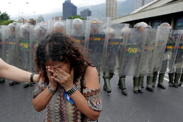 An opposition supporter reacts in front of Venezuelan National Guards in a rally to demand a referendum to remove President Nicolas Maduro in Caracas, Venezuela, May 11, 2016. REUTERS/Marco Bello     TPX IMAGES OF THE DAY      - RTX2DVSA