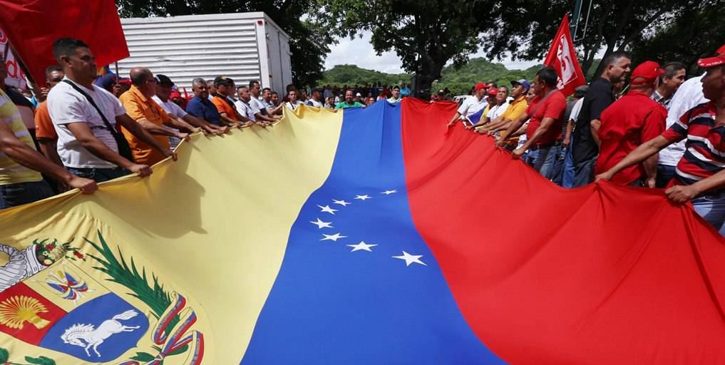 People hold a giant national flag of Venezuela during a demonstration to support Venezuelan President Nicolas Maduro's government in Caracas, Venezuela, on May 31, 2016. 